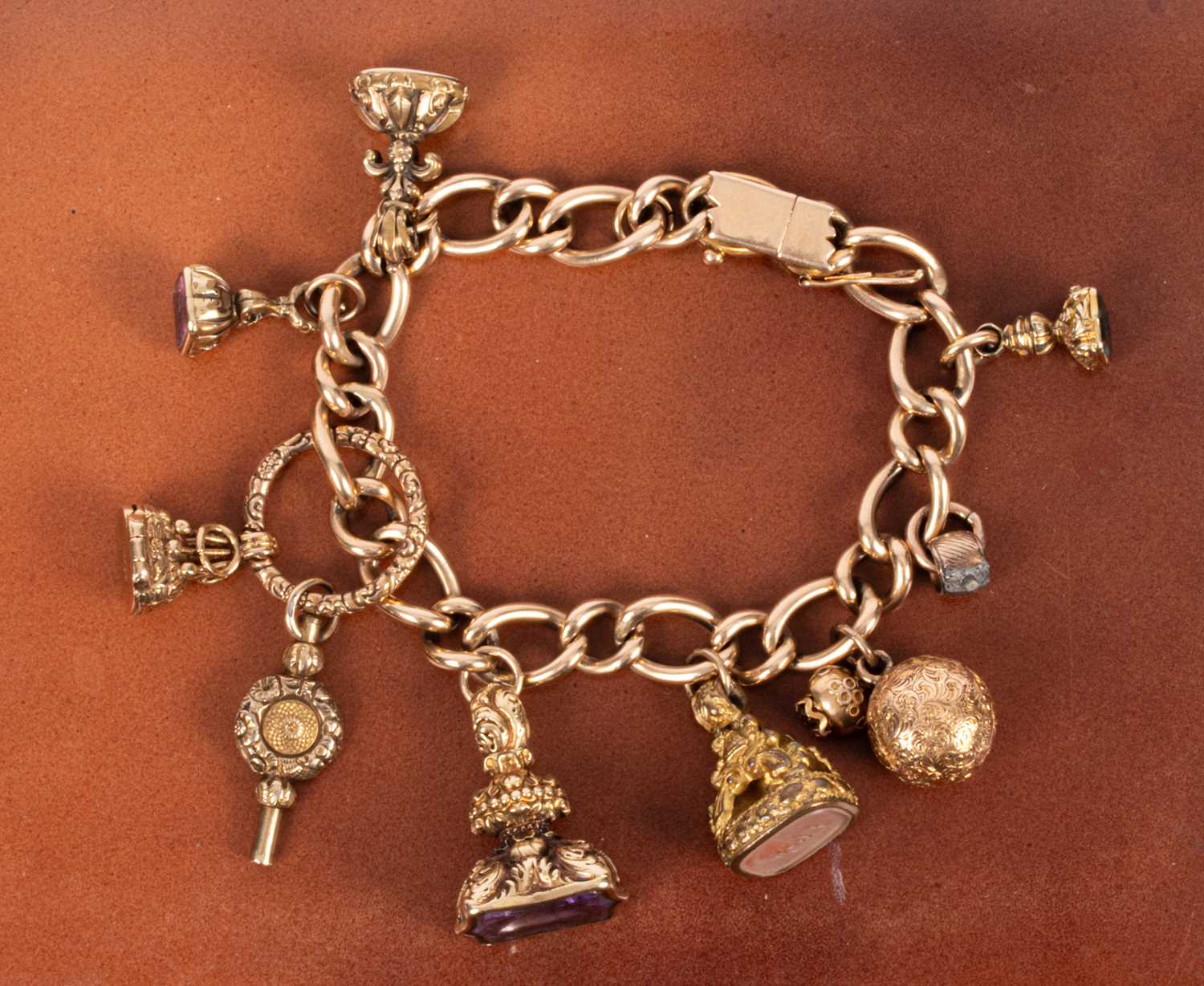 Lot 86 - An 15ct yellow gold curb link charm bracelet