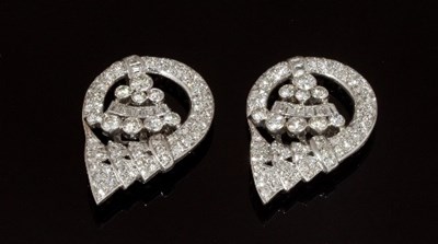 Lot 471 - A pair of diamond set clips of stylised scroll...