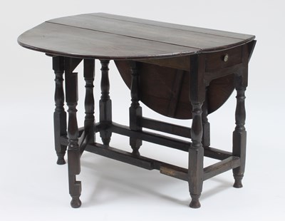 Lot 321 - An oak oval two-flap gateleg table on baluster...