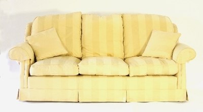 Lot 627 - A pale yellow upholstered three-seater settee,...