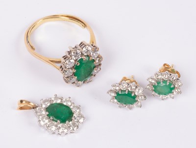 Lot 101 - An 18ct yellow gold emerald and diamond oval cluster ring