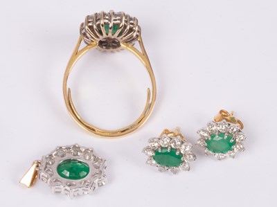 Lot 101 - An 18ct yellow gold emerald and diamond oval cluster ring