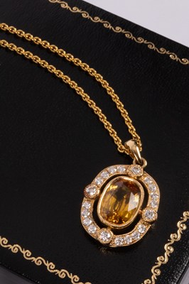 Lot 79 - An 18ct gold, diamond and yellow sapphire pendant