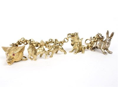 Lot 114 - An 18ct gold bracelet hung with three 14ct...