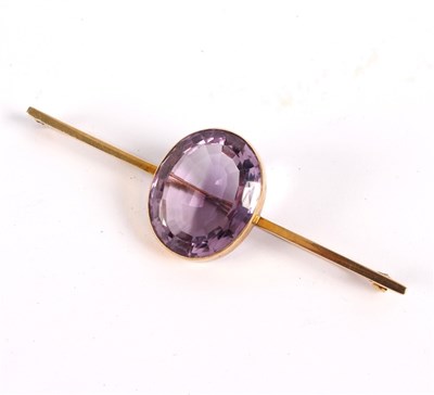 Lot 185 - An amethyst bar brooch, the large oval stone...