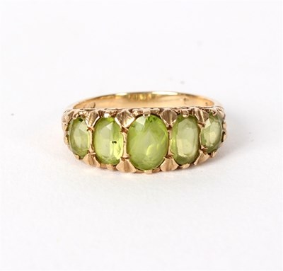 Lot 196 - A peridot ring, the five oval graduated stones...
