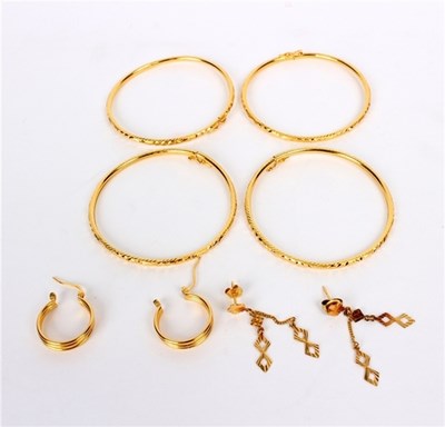 Lot 200 - Four yellow gold bangles and a pair of gold...