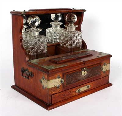 Lot 286 - An oak tantalus, fitted two drawers with...