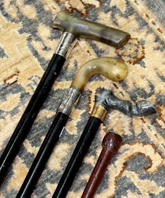 Lot 604 - Three ebonised walking sticks with carved horn...