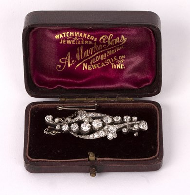 Lot 100 - A diamond brooch of scrolling form, the...