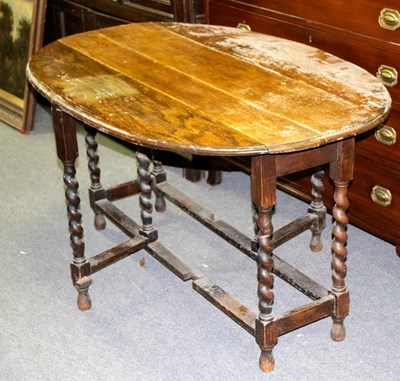 Lot 324 - An oak oval two-flap wake table on spiral...