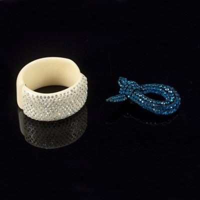 Lot 1 - A white plastic hinged bracelet decorated...