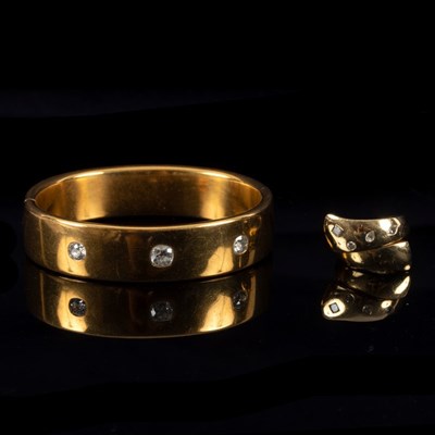 Lot 13 - A French yellow gold hinged bangle set with...