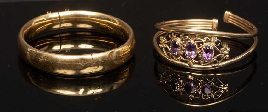 Lot 16 - A 9ct yellow gold bangle set with three oval...
