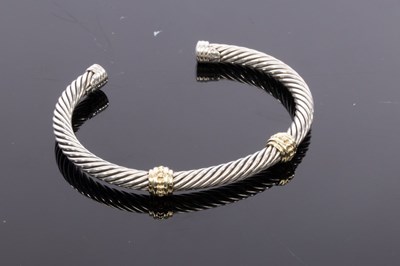 Lot 40 - David Yurman, a silver and gold cable bangle,...