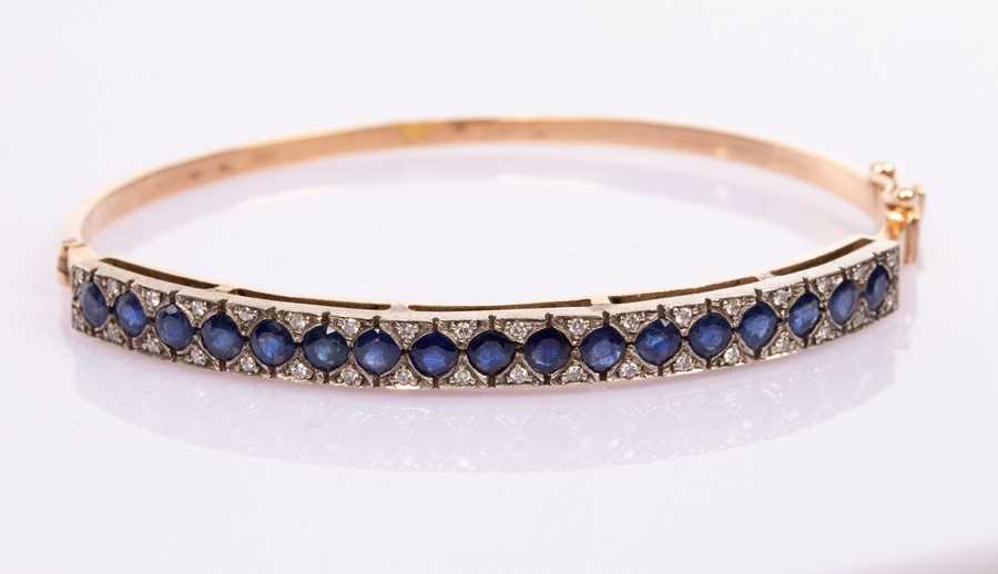Lot 12 - A sapphire and diamond hinged bangle, set in...