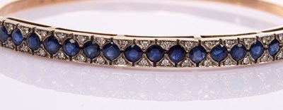 Lot 12 - A sapphire and diamond hinged bangle, set in...