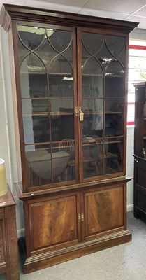 Lot 690 - A mahogany bookcase enclosed by glazed doors...
