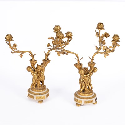 Lot 1263 - A pair of Louis XVI style gilt-metal and white marble three-light candelabra