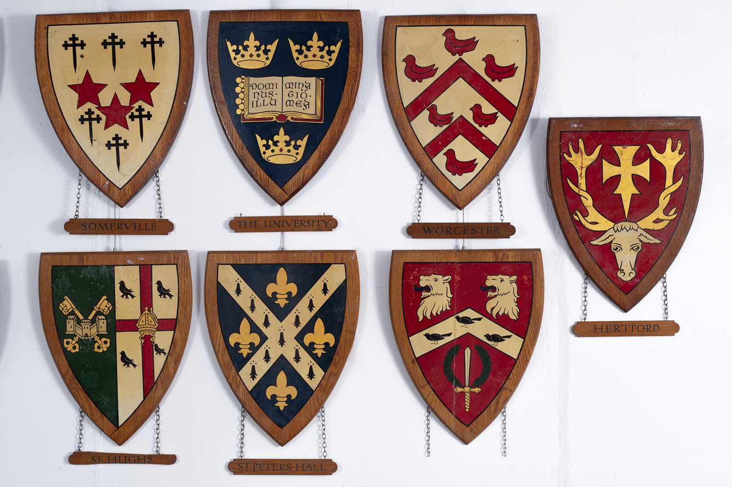Lot 7 - A collection of painted wood university heraldic shields