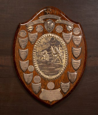 Lot 494 - A silver mounted oak shield-shaped S.S.C.S. Cricket League trophy