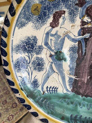 Lot 717 - An English Delftware Adam & Eve blue dash charger