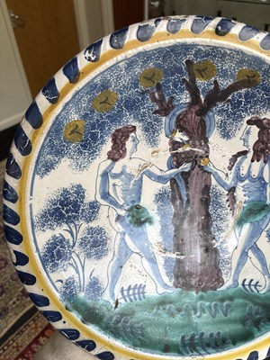 Lot 717 - An English Delftware Adam & Eve blue dash charger