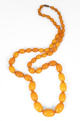 Lot 233 - An early 20th Century string of graduated amber coloured Bakelite beads