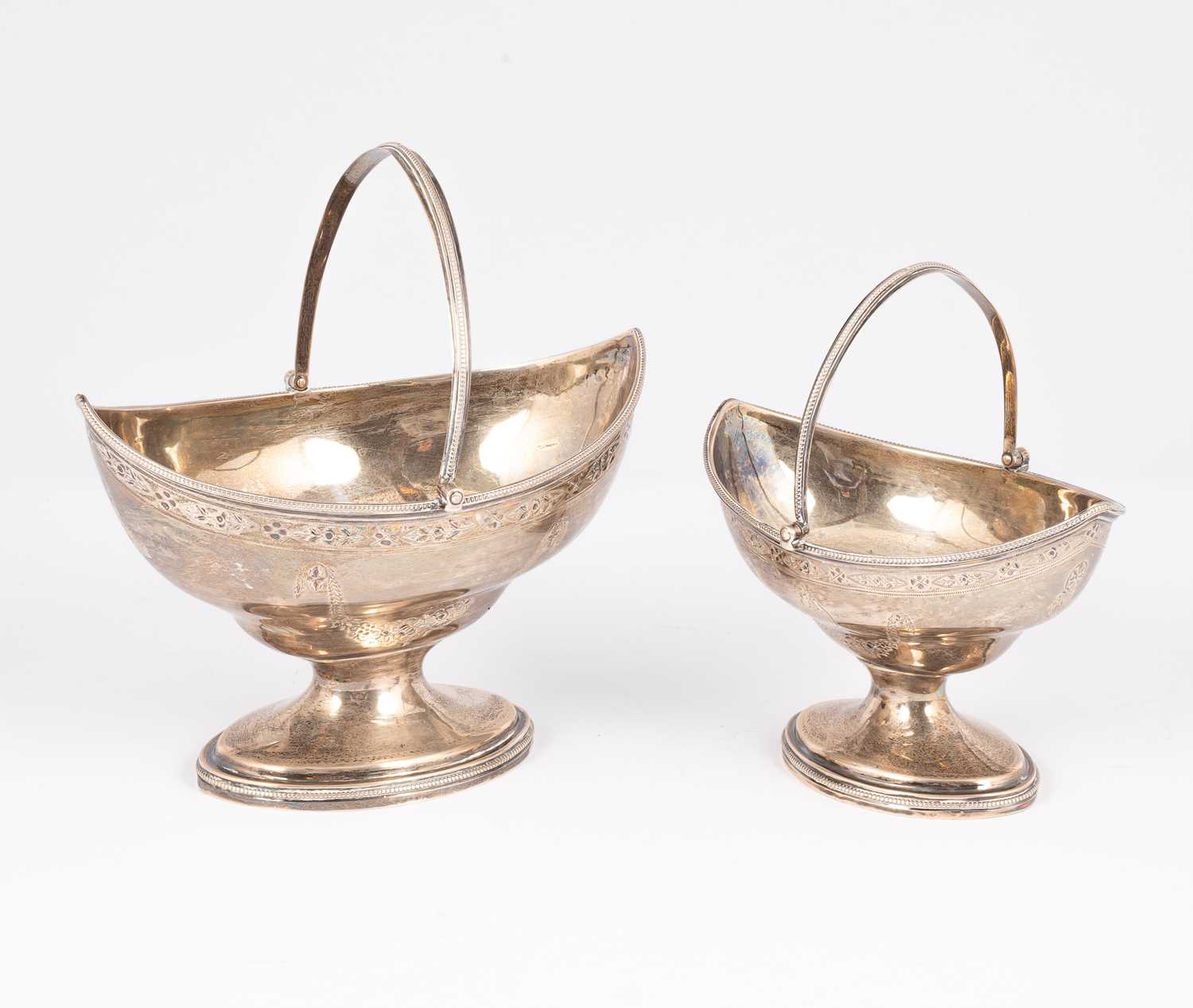 Lot 73 - Two George III graduated swing handled silver baskets