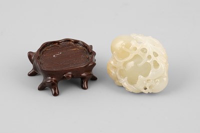 Lot 308 - A small pale celadon jade pomegranate carving with a three-legged toad