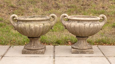 Lot 504 - A pair of gadrooned twin-handled composition stone urns